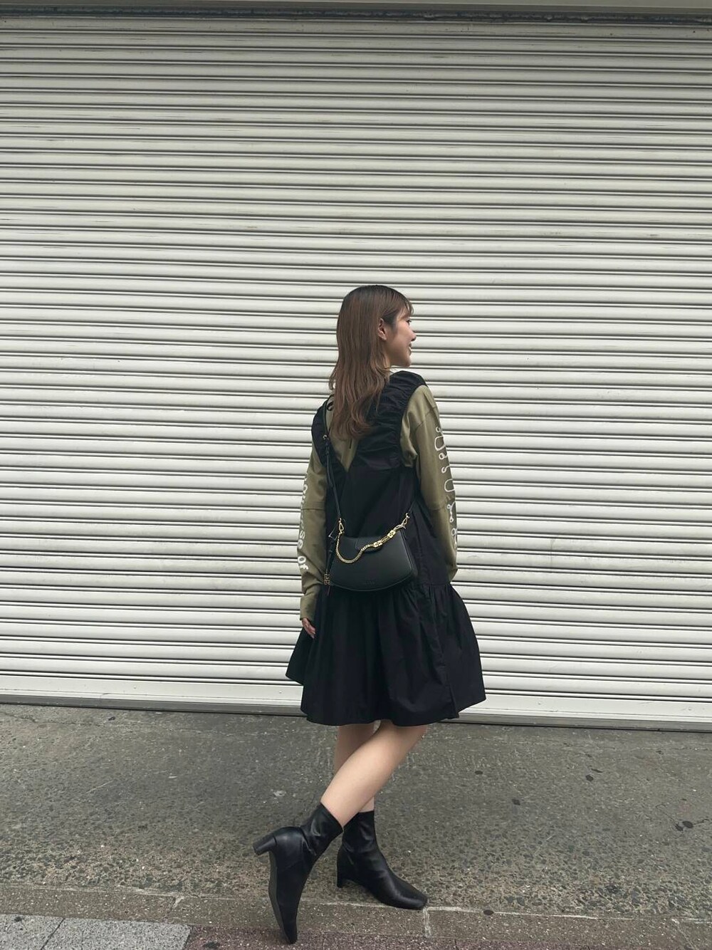 ベージュ系のTシャツ/カットソー、ブラック系のハンドバッグ、ブラック系のワンピースを着用したレディースの秋コーディネートの2枚目の写真