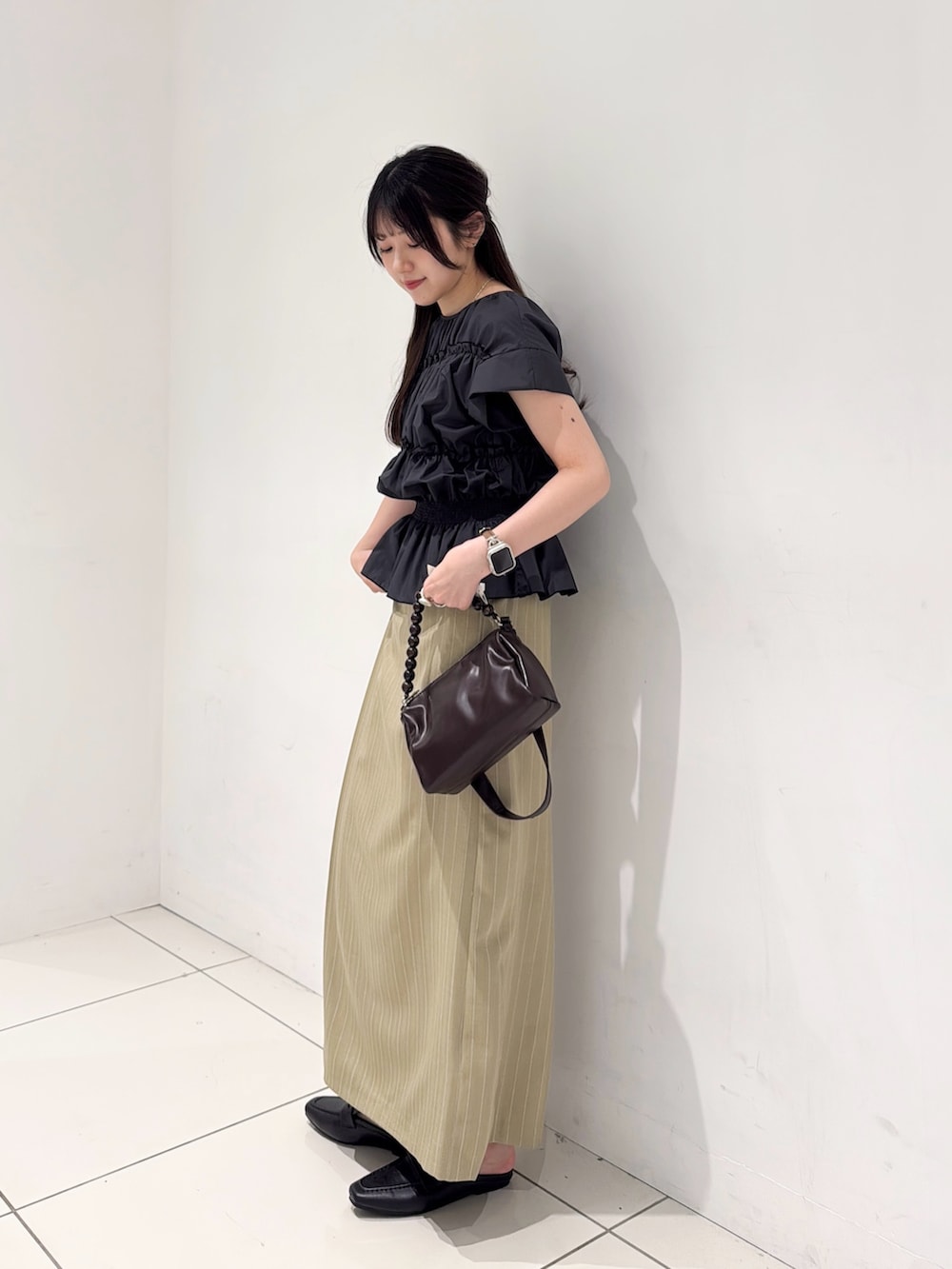 グレー系のシャツ/ブラウス、ベージュ系のスカート、ブラウン系のショルダーバッグを着用したレディースの夏コーディネートの4枚目の写真