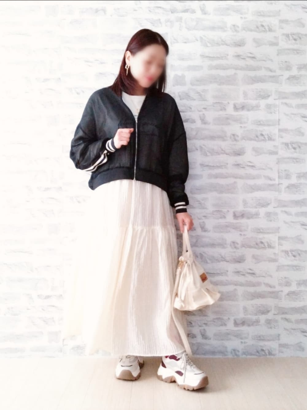 ホワイト系のTシャツ/カットソー、ブラック系のブルゾン、ホワイト系のスカートを着用したレディースの春コーディネートの2枚目の写真