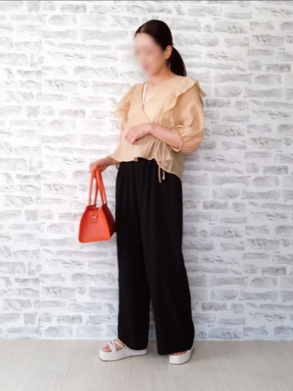 ホワイト系のキャミソール、オレンジ系のカーディガン/ボレロ、ブラック系のその他パンツを着用したレディースの夏コーディネートの3枚目の写真