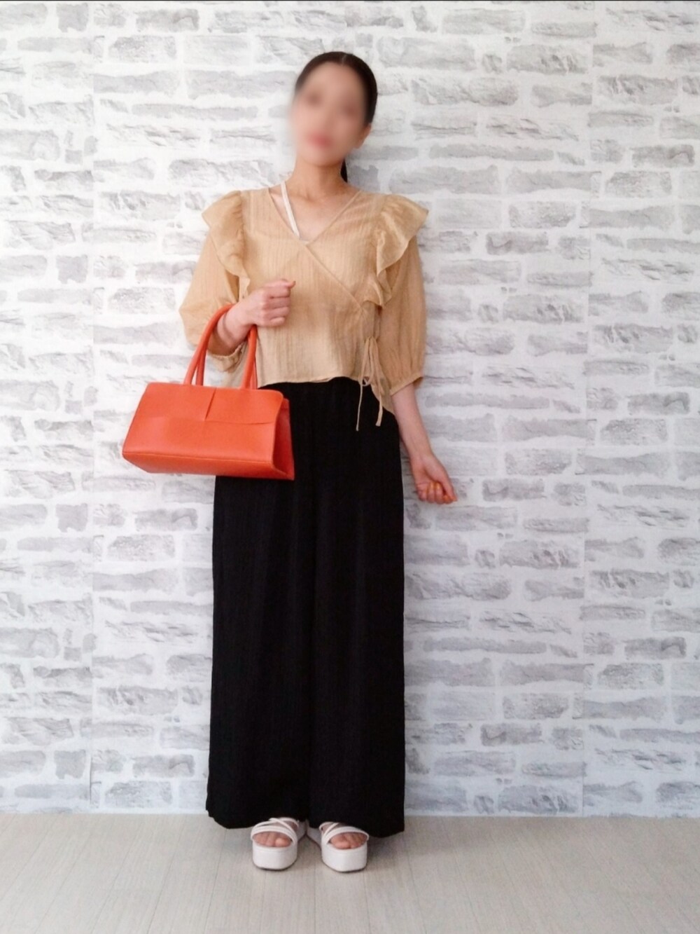 ホワイト系のキャミソール、オレンジ系のカーディガン/ボレロ、ブラック系のその他パンツを着用したレディースの夏コーディネートの2枚目の写真