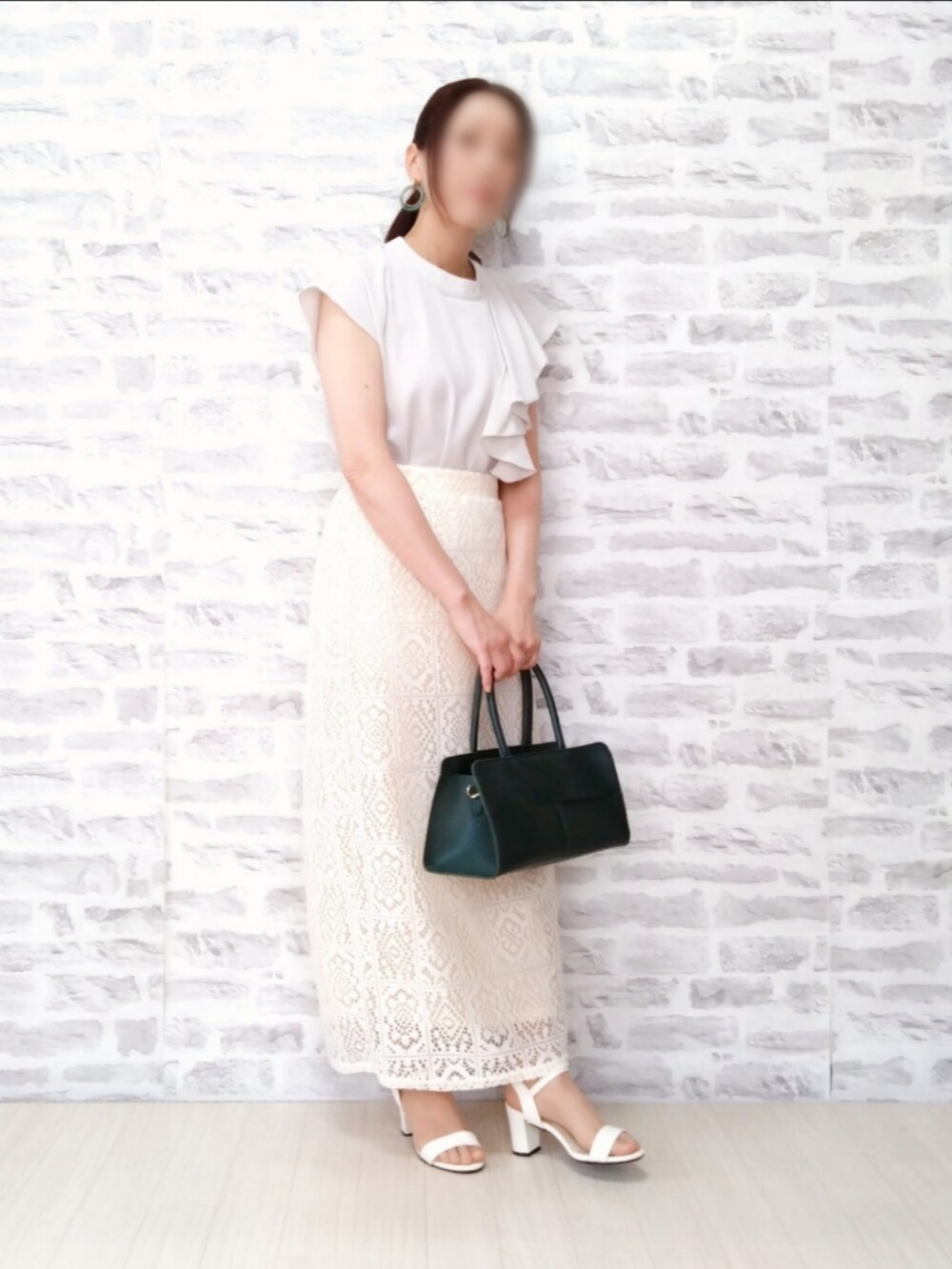 ホワイト系のシャツ/ブラウス、ホワイト系のスカート、グリーン系のハンドバッグを着用したレディースの夏コーディネートの2枚目の写真