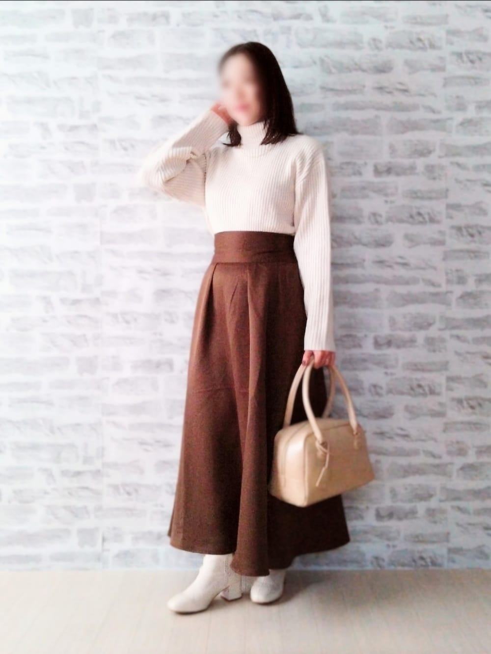 ベージュ系のニット/セーター、ブラウン系のスカート、ホワイト系のブーツを着用したレディースの冬コーディネートの2枚目の写真