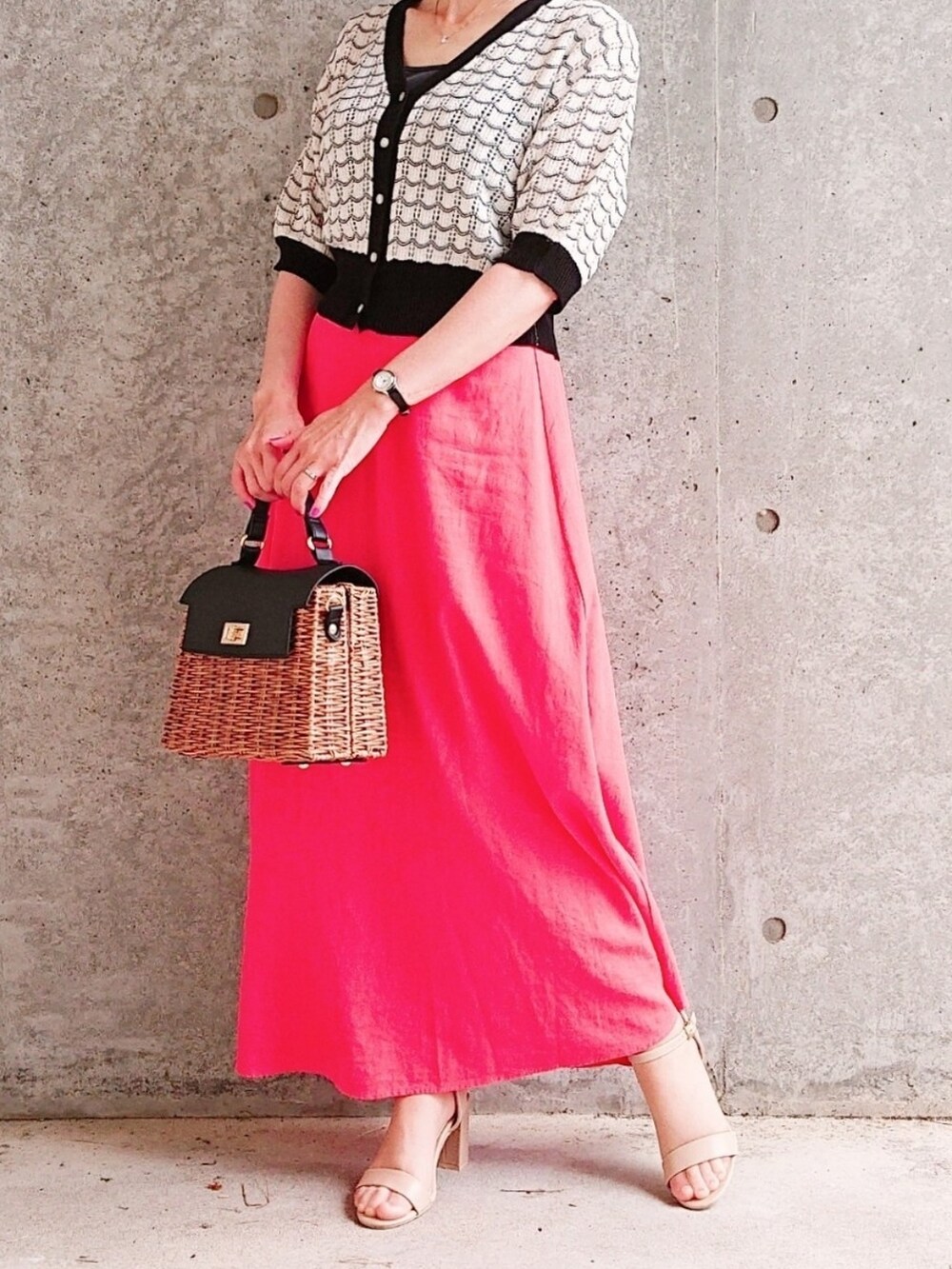 ブラック系のカーディガン/ボレロ、オレンジ系のスカート、ブラウン系のバッグを着用したレディースの夏コーディネートの2枚目の写真