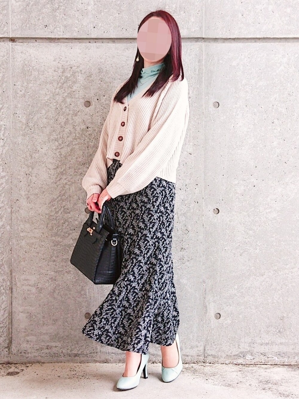 ブルー系のトップス、ベージュ系のカーディガン/ボレロ、ブラック系のスカートを着用したレディースの春コーディネートの2枚目の写真