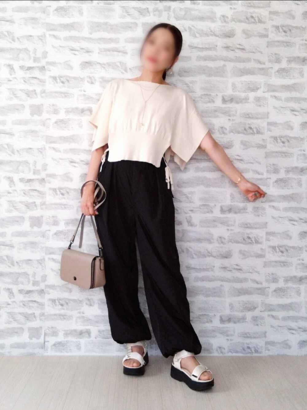ホワイト系のニット/セーター、ブラック系のカーゴパンツ、ベージュ系のショルダーバッグを着用したレディースの夏コーディネートの2枚目の写真