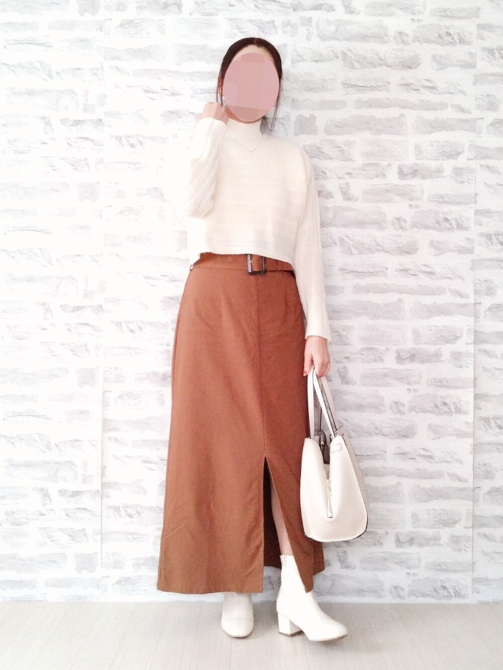 ブラック系のブルゾン、ホワイト系のニット/セーター、ブラウン系のスカートを着用したレディースの冬コーディネートの2枚目の写真