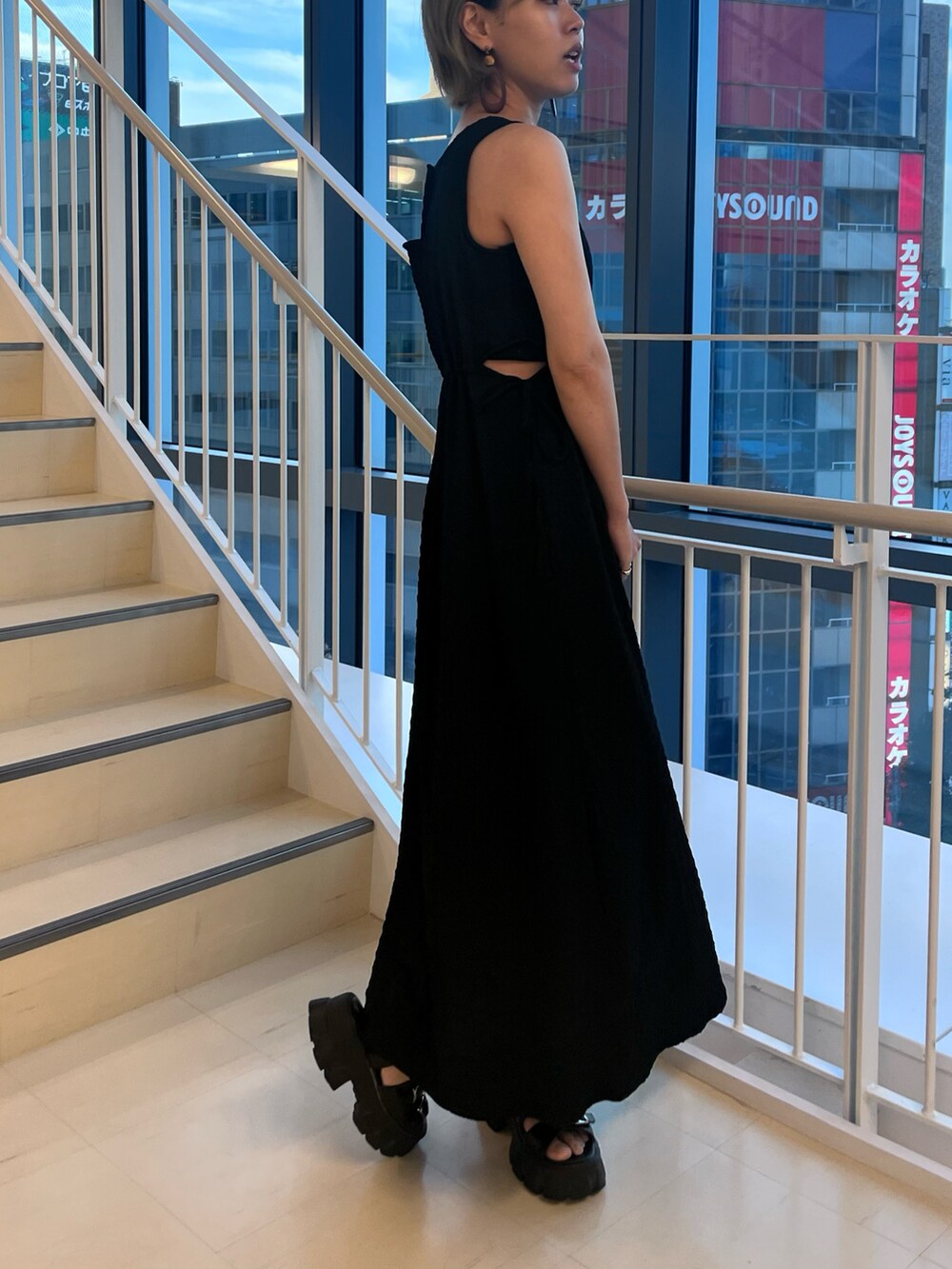 ブラック系のワンピース、シルバー系のショルダーバッグを着用したレディースの夏コーディネートの2枚目の写真