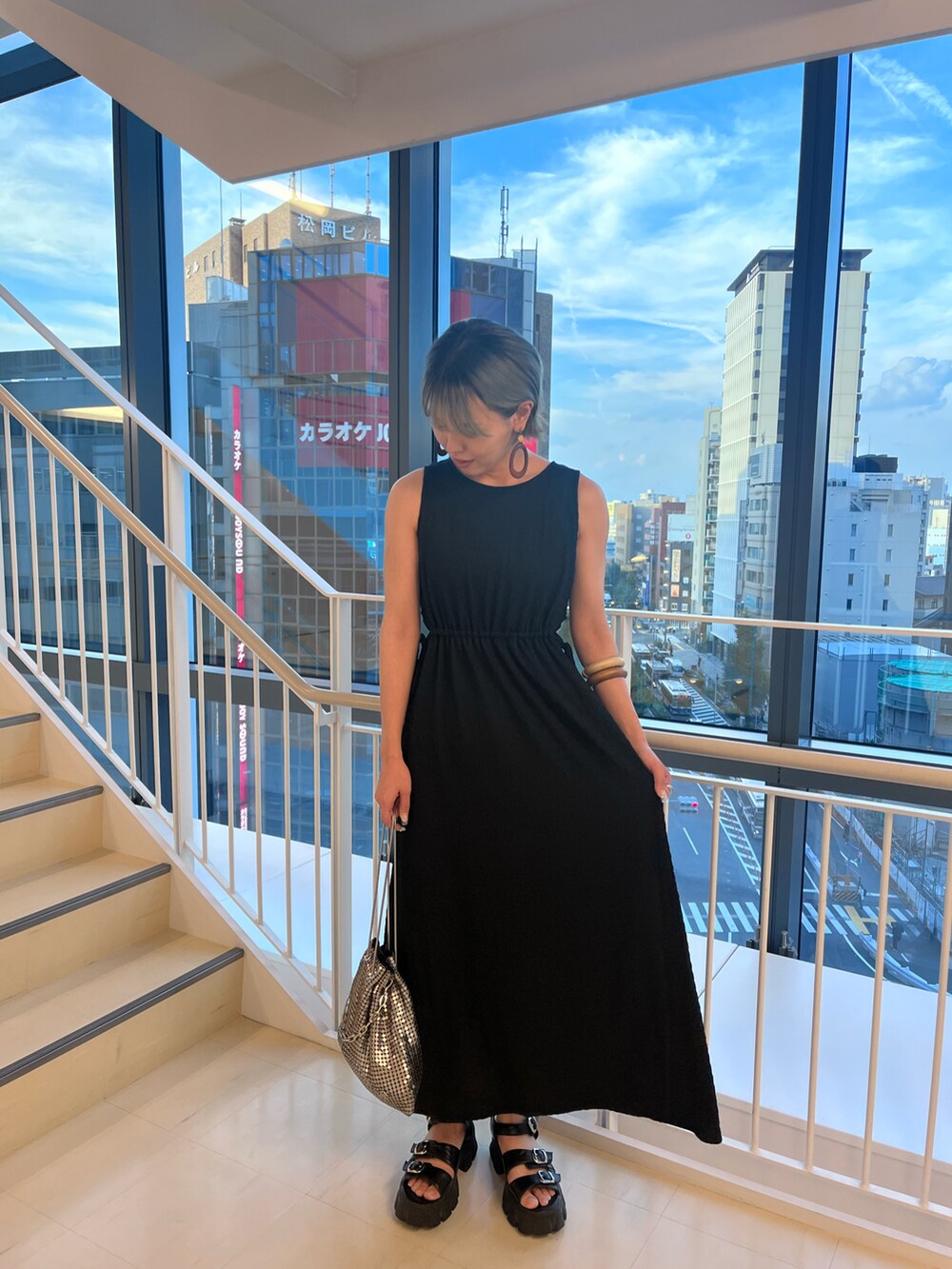 ブラック系のワンピース、シルバー系のショルダーバッグを着用したレディースの夏コーディネートの4枚目の写真