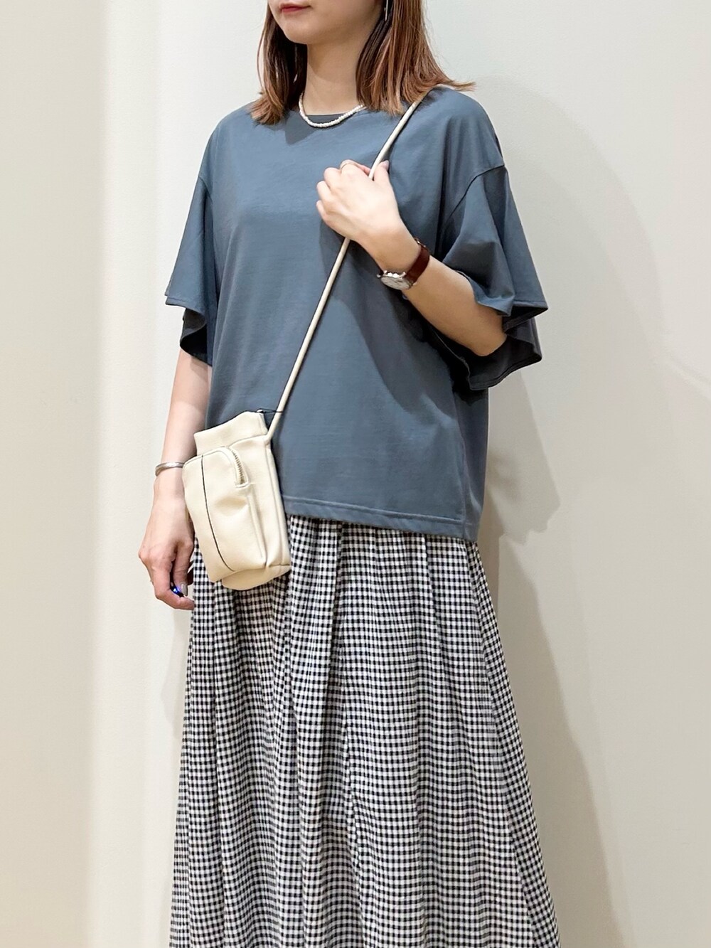 ホワイト系のショルダーバッグ、ホワイト系のサンダル、その他のスカートを着用したレディースの夏コーディネートの3枚目の写真