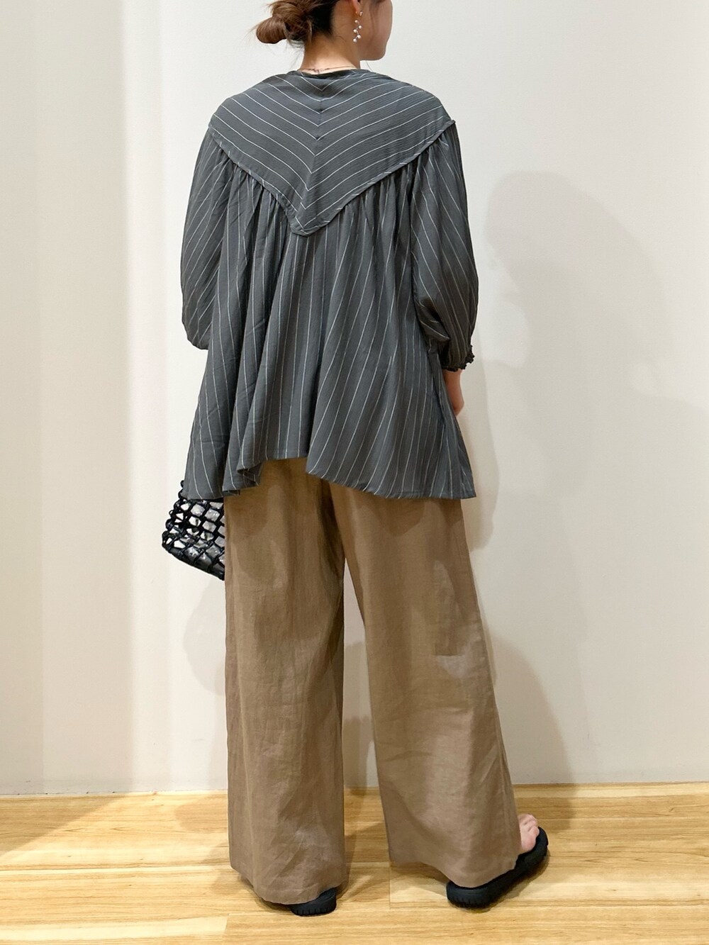 グリーン系のシャツ/ブラウス、ブラウン系のその他パンツ、ブラック系のハンドバッグを着用したレディースの春コーディネートの3枚目の写真