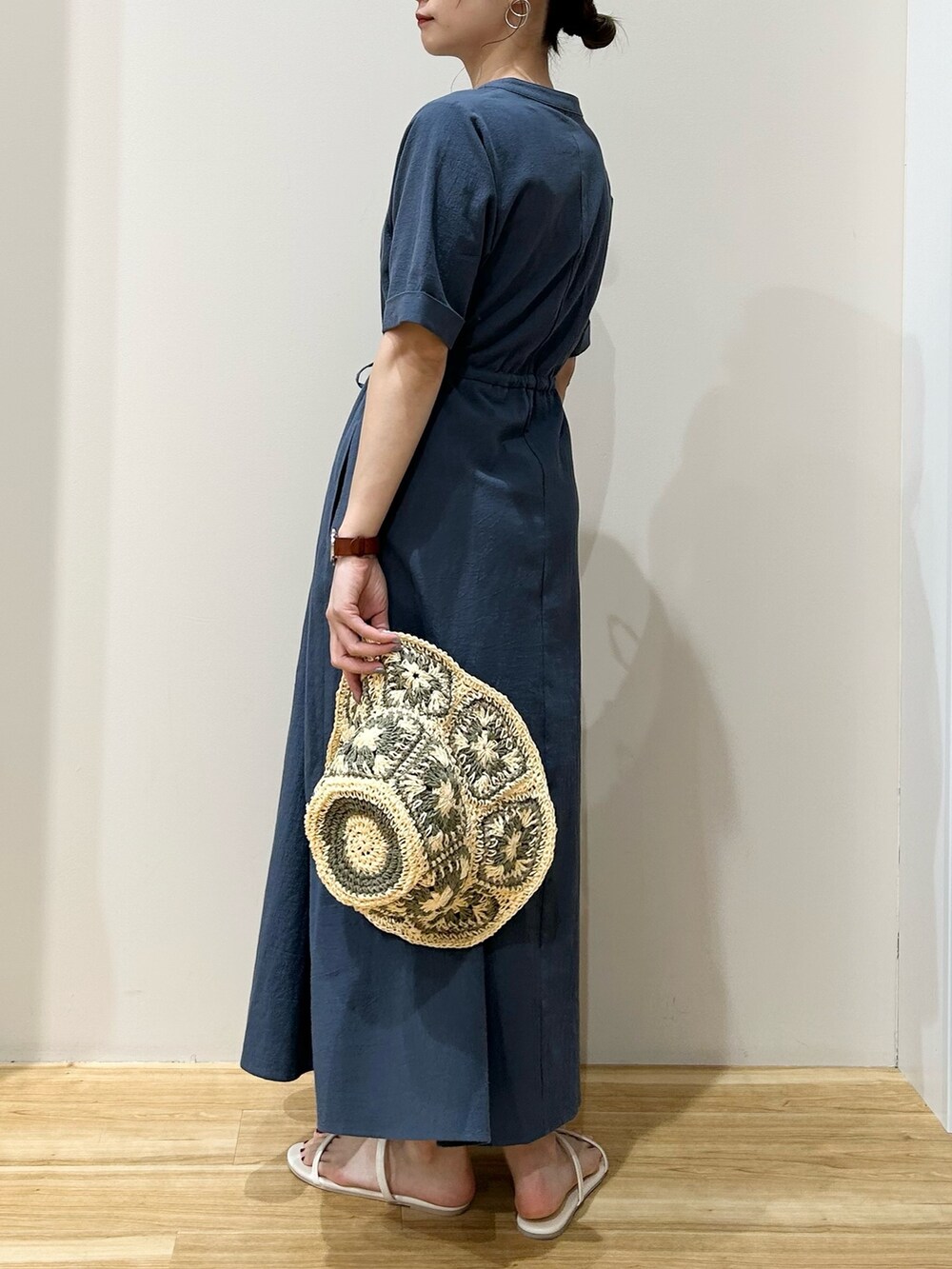 ブルー系のワンピース、ホワイト系のサンダル、ホワイト系のハットを着用したレディースの夏コーディネートの2枚目の写真