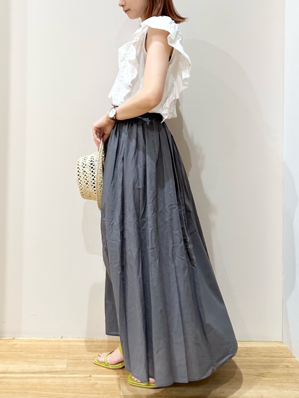 ホワイト系のTシャツ/カットソー、グレー系のスカート、イエロー系のサンダルを着用したレディースの夏コーディネートの3枚目の写真