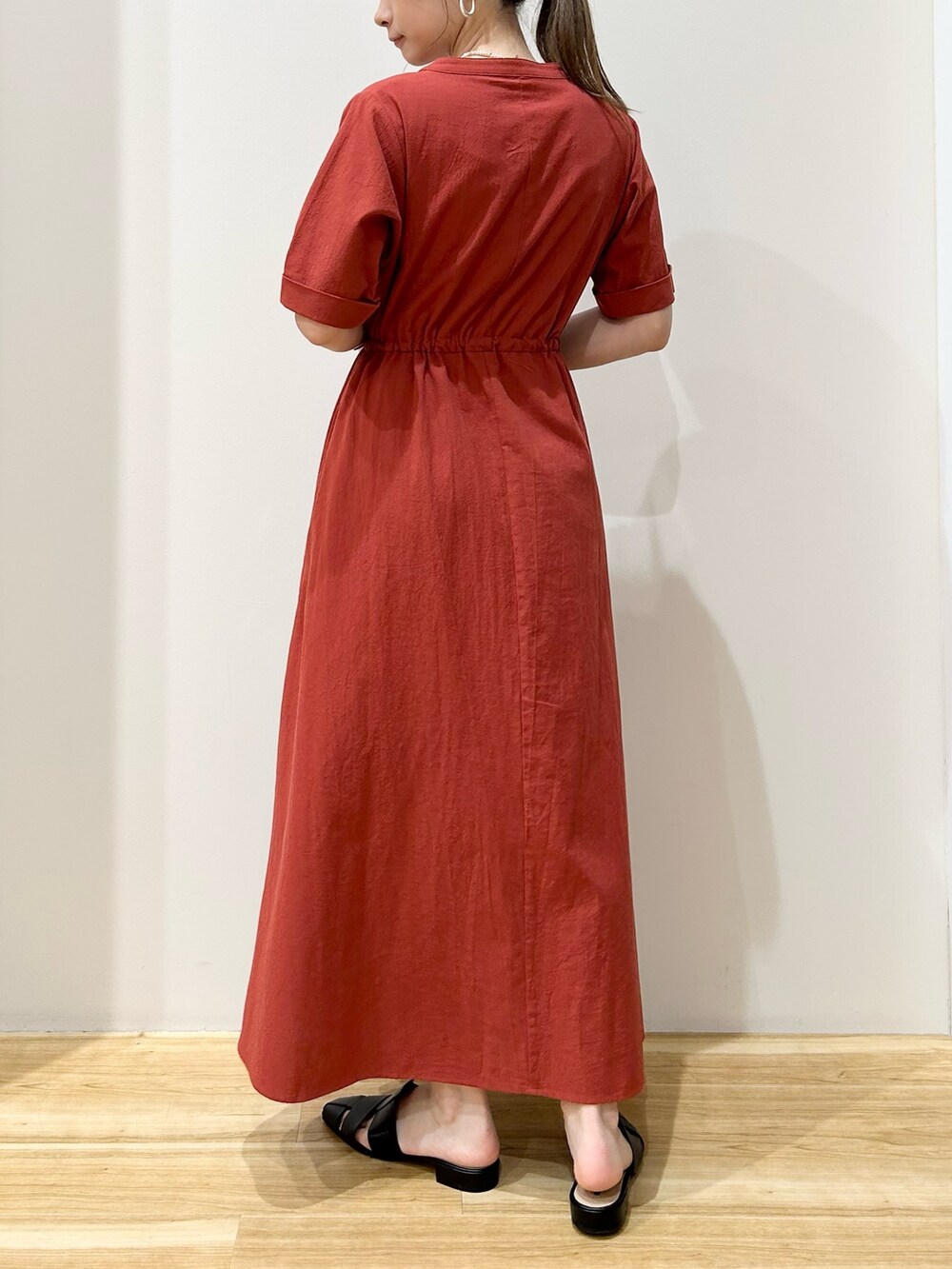 レッド系のワンピース、ブラック系のサンダルを着用したレディースの夏コーディネートの3枚目の写真