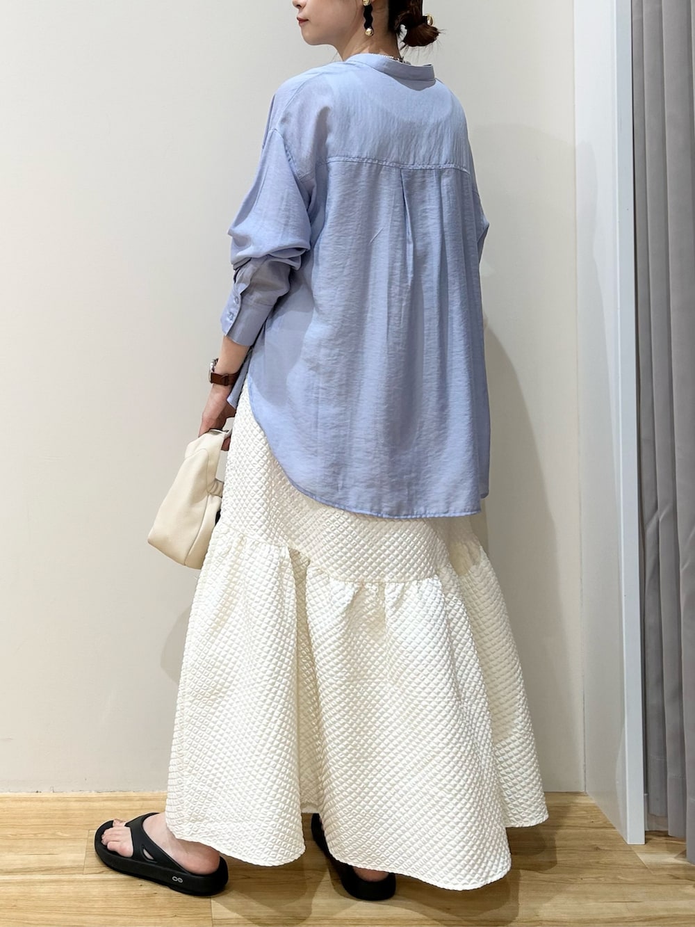 ブルー系のシャツ/ブラウス、ホワイト系のハンドバッグ、ブラック系のサンダルを着用したレディースの夏コーディネートの2枚目の写真
