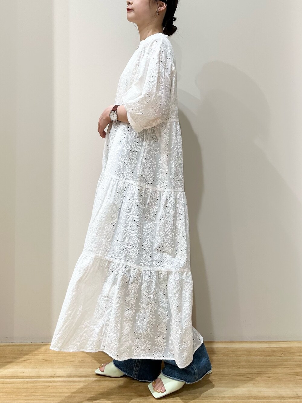 ホワイト系のワンピース、ブルー系のデニムパンツ、グリーン系のサンダルを着用したレディースの夏コーディネートの2枚目の写真