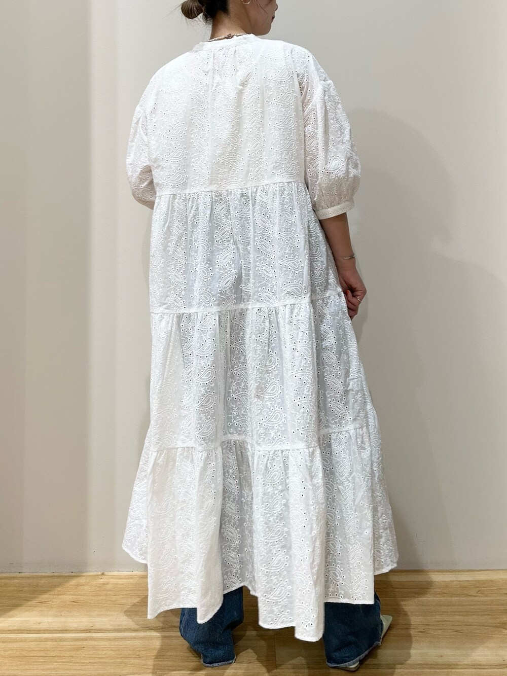 ホワイト系のワンピース、ブルー系のデニムパンツ、グリーン系のサンダルを着用したレディースの夏コーディネートの3枚目の写真