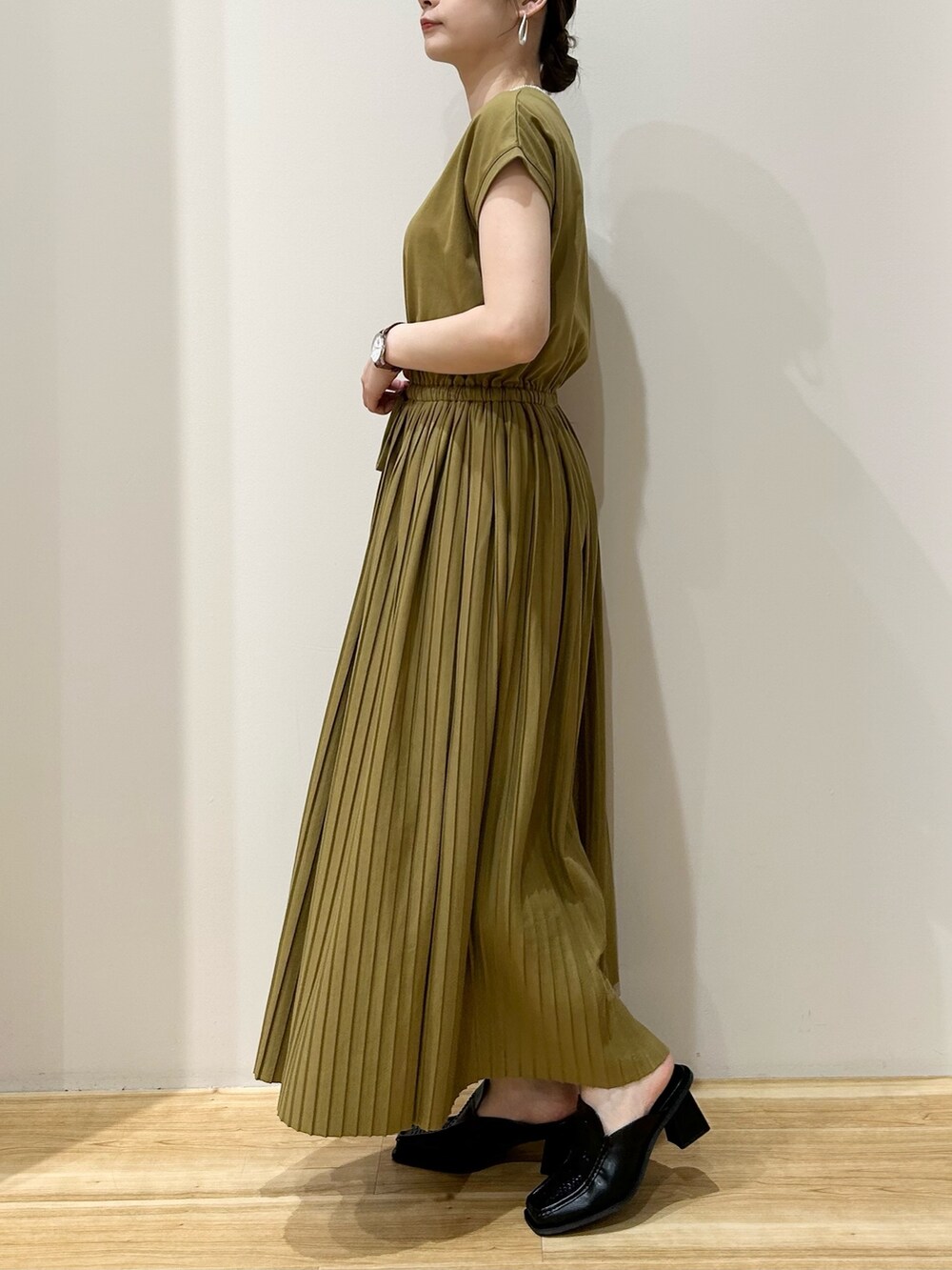 イエロー系のワンピース、ブラック系のサンダルを着用したレディースの夏コーディネートの2枚目の写真