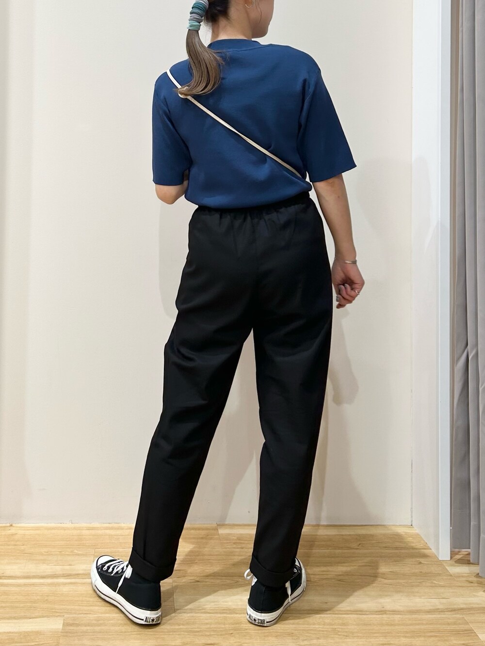 ブルー系のニット/セーター、ホワイト系のショルダーバッグ、ブラック系のその他パンツを着用したレディースの春コーディネートの2枚目の写真