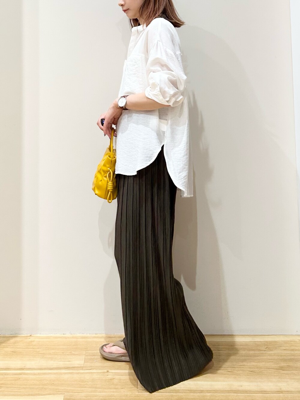 イエロー系のショルダーバッグ、グレー系のサンダル、ブラウン系のその他パンツを着用したレディースの夏コーディネートの2枚目の写真