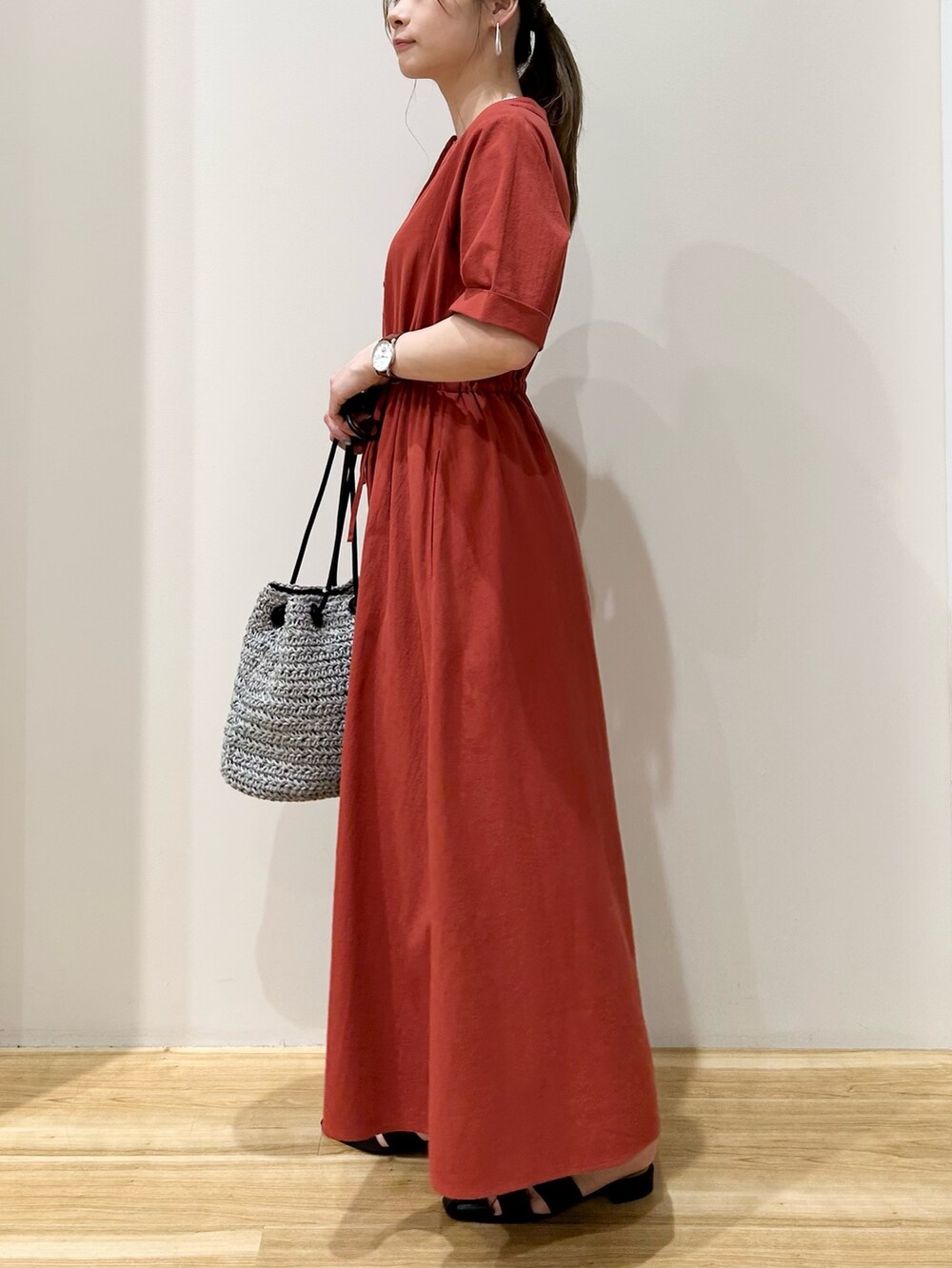 レッド系のワンピース、ブラック系のサンダルを着用したレディースの夏コーディネートの2枚目の写真