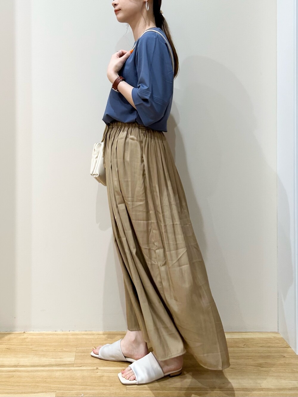 ブルー系のTシャツ/カットソー、ホワイト系のショルダーバッグ、ベージュ系のその他パンツを着用したレディースの夏コーディネートの2枚目の写真