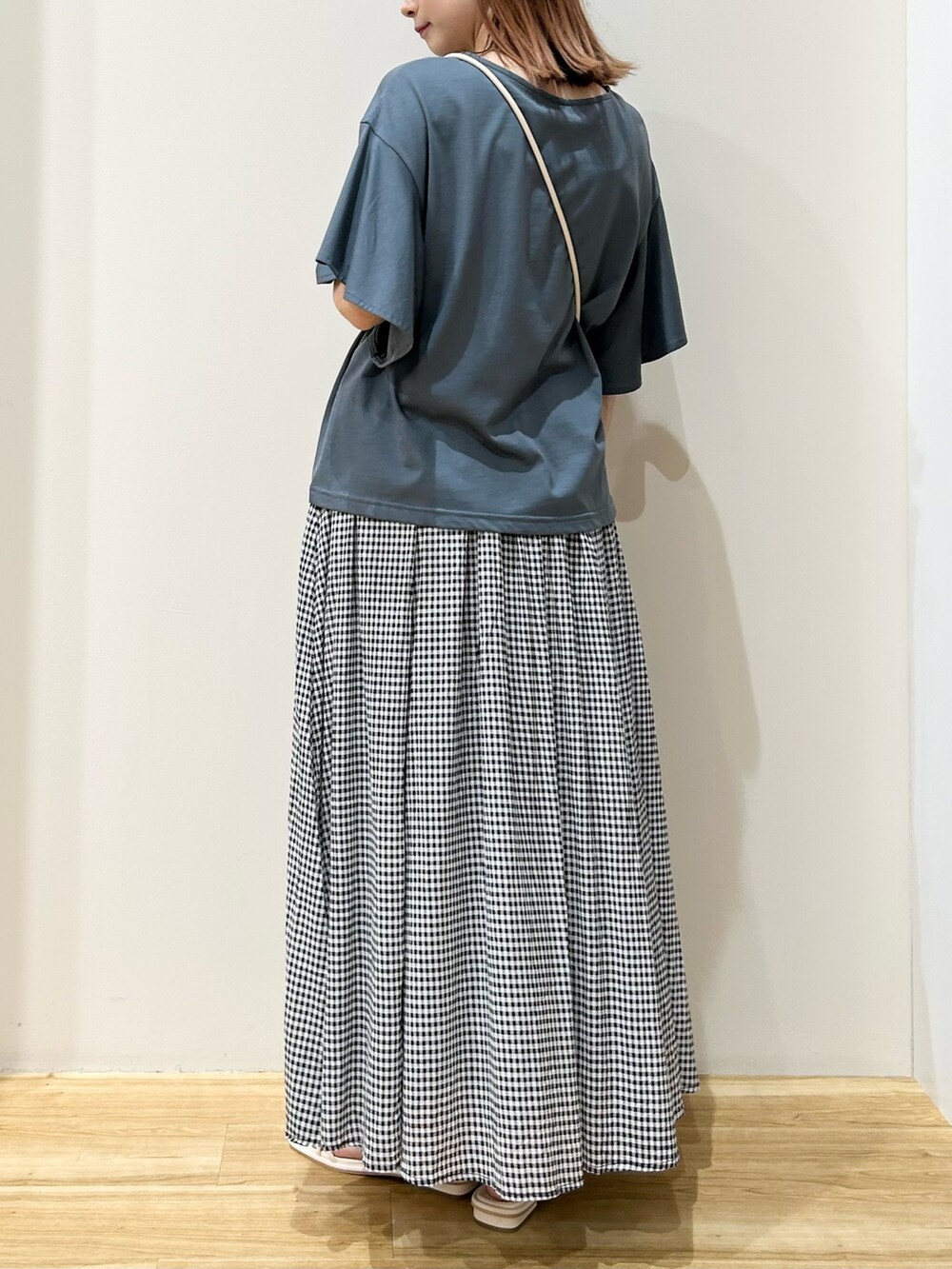 ホワイト系のショルダーバッグ、ホワイト系のサンダル、その他のスカートを着用したレディースの夏コーディネートの2枚目の写真