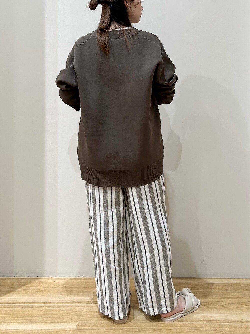 ホワイト系のTシャツ/カットソー、ブラウン系のカーディガン/ボレロ、ホワイト系のハンドバッグを着用したレディースの春コーディネートの3枚目の写真