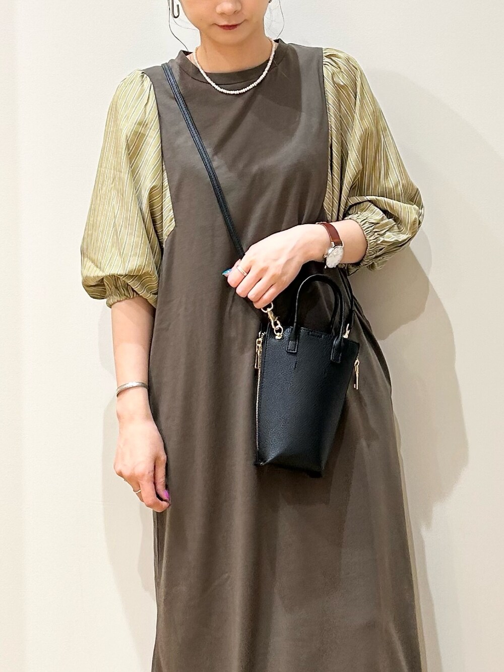 ブラック系のショルダーバッグ、ブラック系のサンダル、ブラウン系のワンピースを着用したレディースの夏コーディネートの4枚目の写真