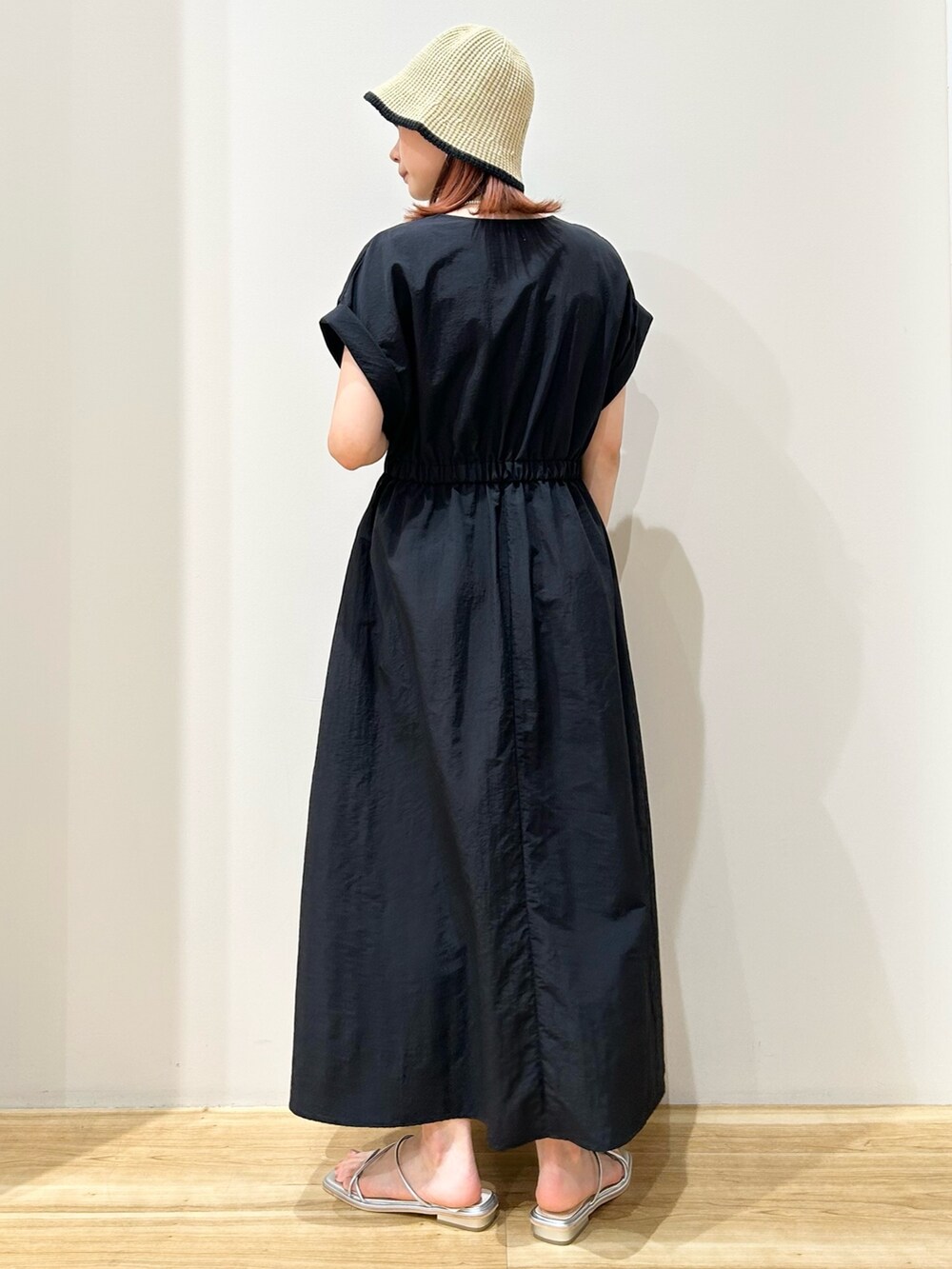 ブラック系のワンピース、シルバー系のサンダル、ベージュ系のハットを着用したレディースの夏コーディネートの3枚目の写真