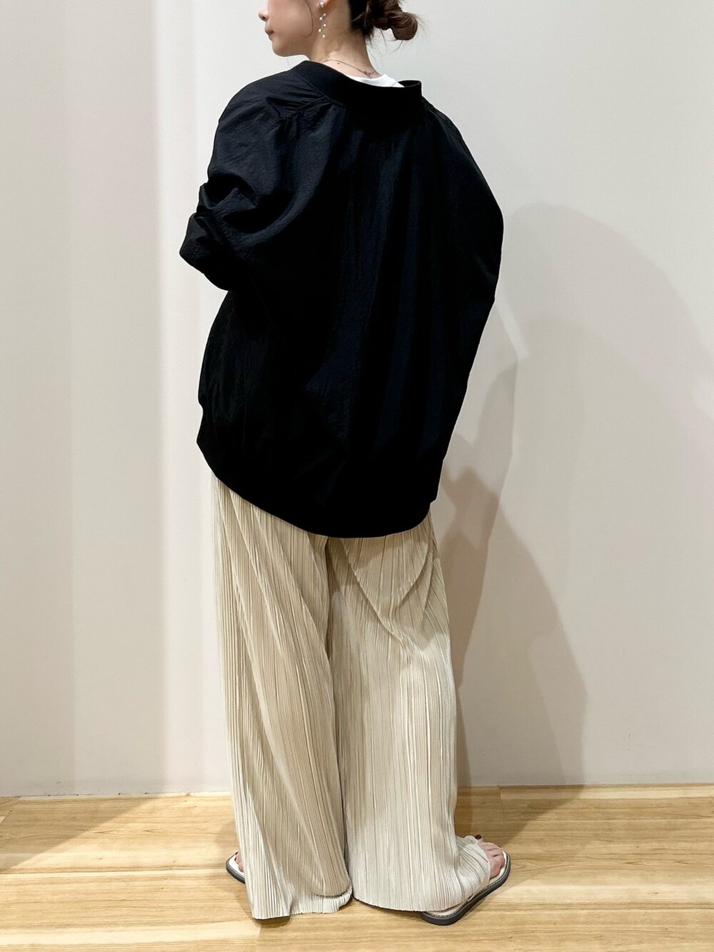 ホワイト系のTシャツ/カットソー、ブラック系のブルゾン、ベージュ系のその他パンツを着用したレディースの春コーディネートの2枚目の写真