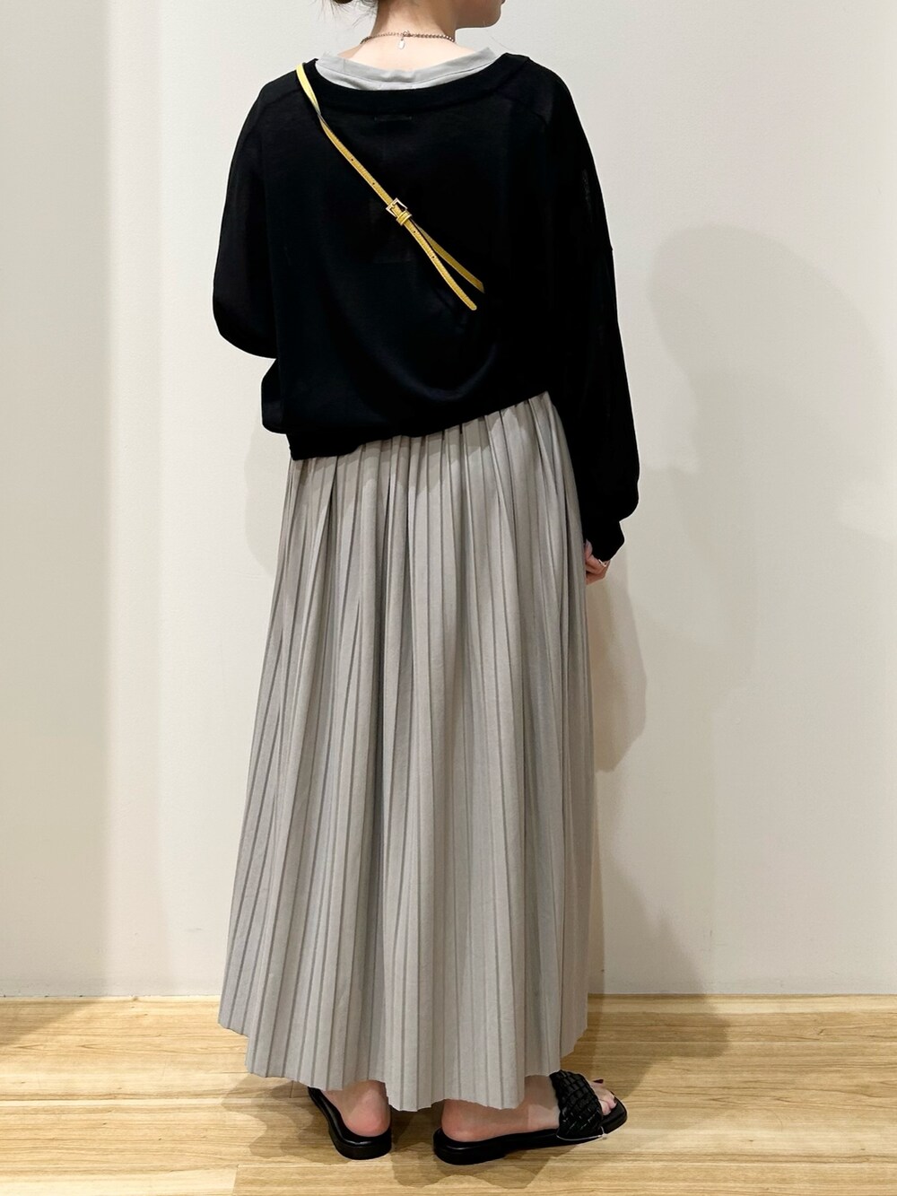 イエロー系のショルダーバッグ、グレー系のワンピース、ブラック系のカーディガン/ボレロを着用したレディースの夏コーディネートの3枚目の写真