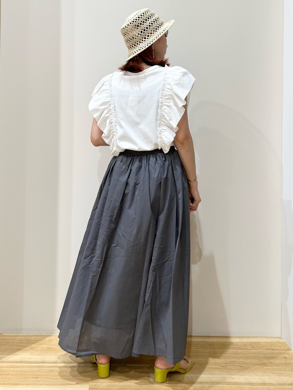 ホワイト系のTシャツ/カットソー、グレー系のスカート、イエロー系のサンダルを着用したレディースの夏コーディネートの2枚目の写真