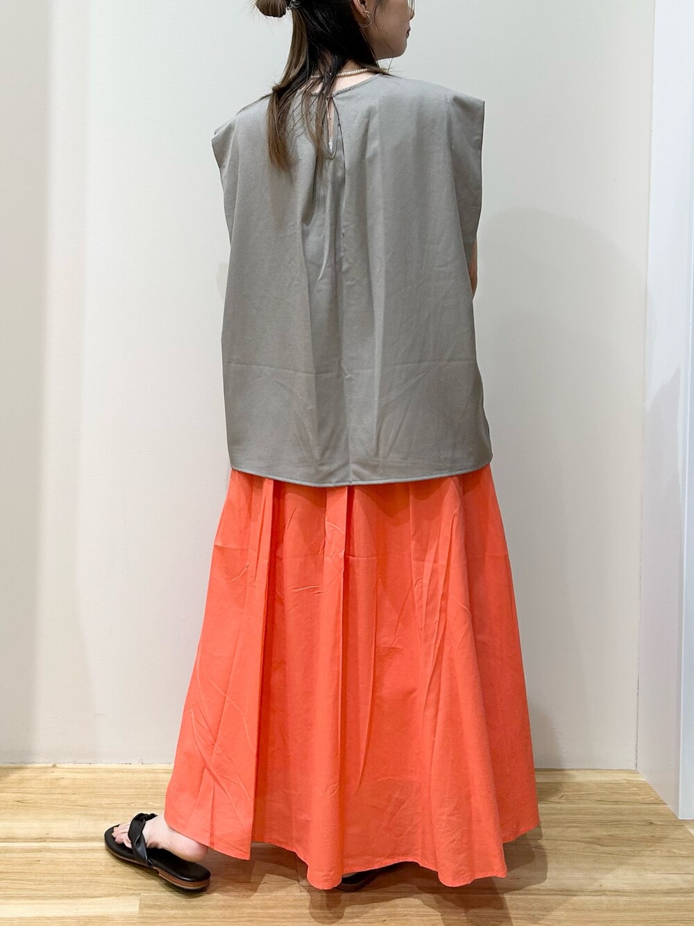 ブラック系のハンドバッグ、オレンジ系のスカート、グレー系のTシャツ/カットソーを着用したレディースの夏コーディネートの3枚目の写真