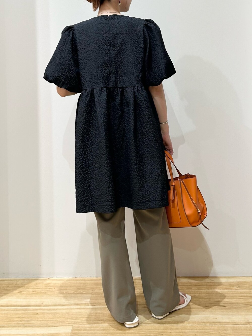 ブラック系のTシャツ/カットソー、オレンジ系のトートバッグ、ホワイト系のサンダルを着用したレディースの夏コーディネートの3枚目の写真