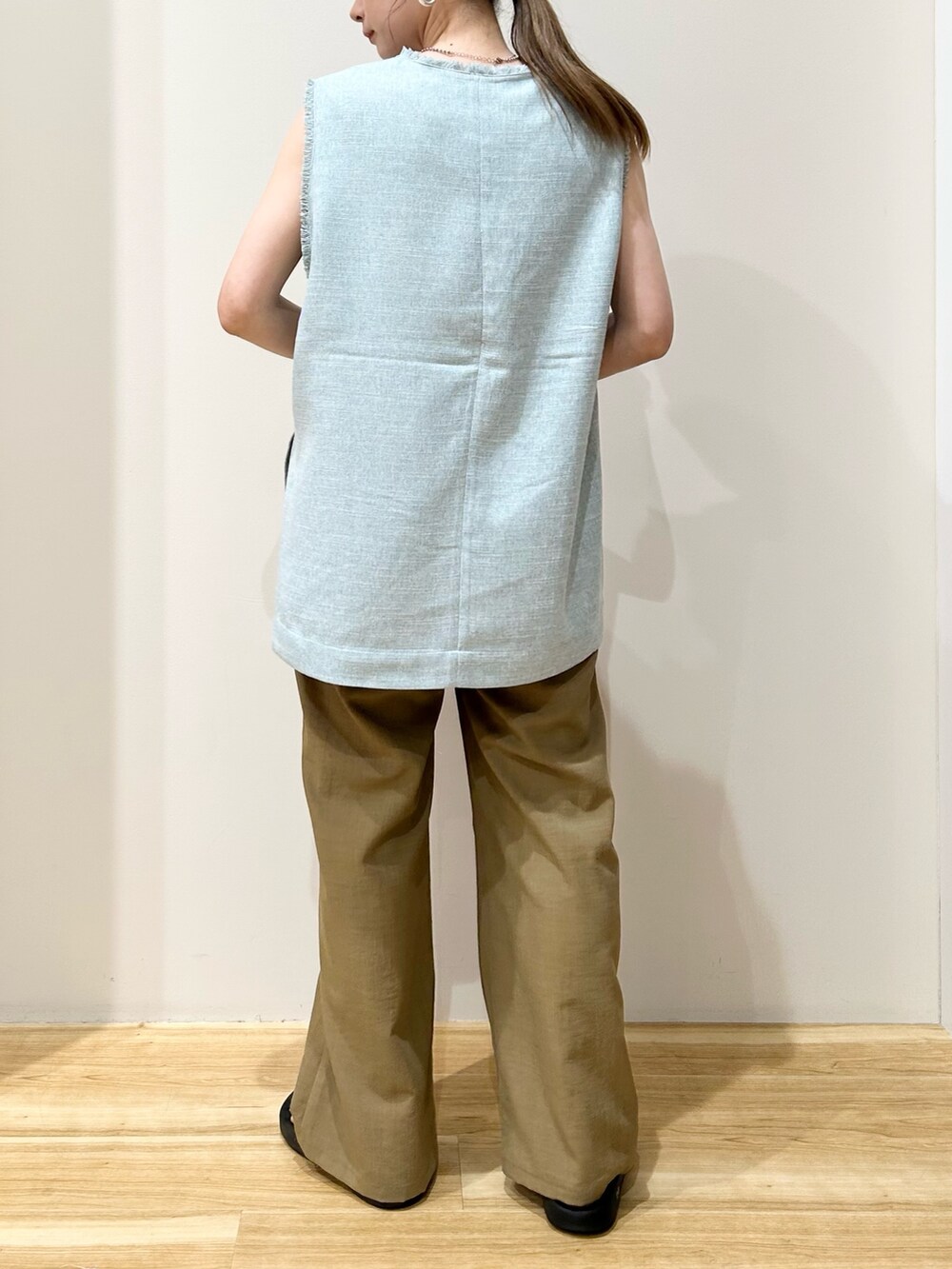 グリーン系のベスト、ブラック系のハンドバッグ、ブラック系のサンダルを着用したレディースの夏コーディネートの3枚目の写真