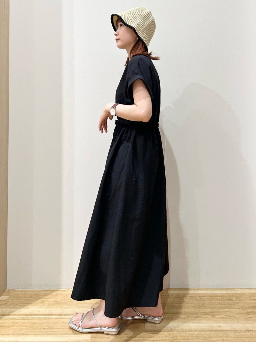 ブラック系のワンピース、シルバー系のサンダル、ベージュ系のハットを着用したレディースの夏コーディネートの2枚目の写真
