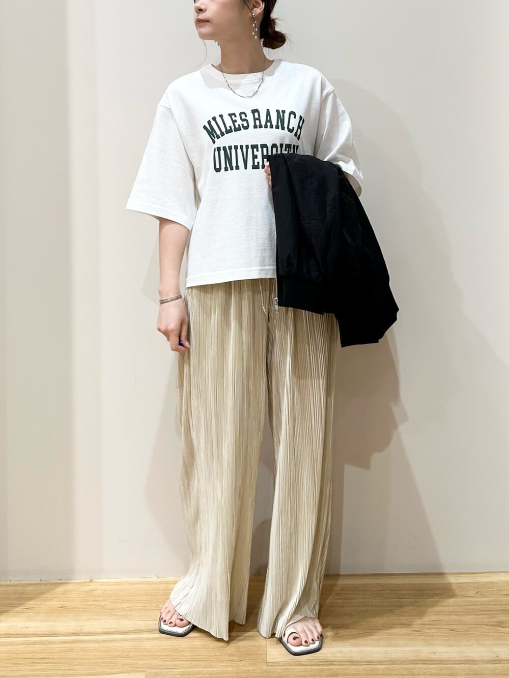 ホワイト系のTシャツ/カットソー、ブラック系のブルゾン、ベージュ系のその他パンツを着用したレディースの春コーディネートの3枚目の写真