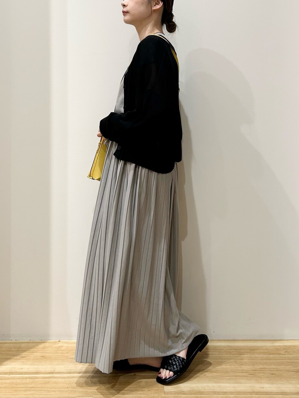 イエロー系のショルダーバッグ、グレー系のワンピース、ブラック系のカーディガン/ボレロを着用したレディースの夏コーディネートの2枚目の写真