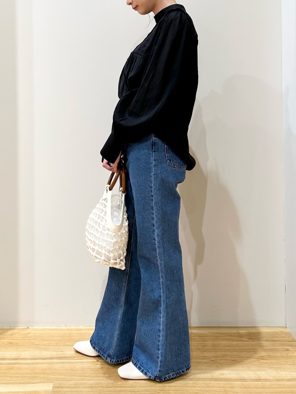 ホワイト系のその他シューズ、ホワイト系のハンドバッグ、ブルー系のデニムパンツを着用したレディースの春コーディネートの4枚目の写真