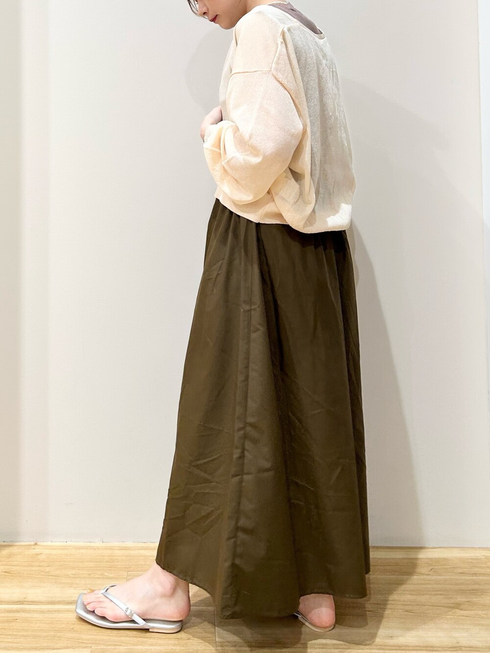 ホワイト系のカーディガン/ボレロ、ブラウン系のワンピース、シルバー系のサンダルを着用したレディースの夏コーディネートの2枚目の写真