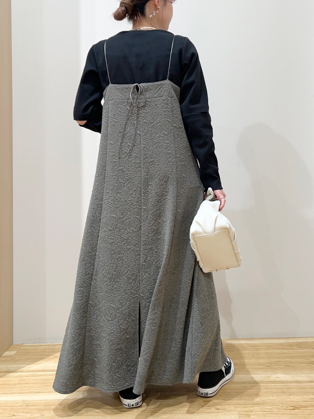 ブラック系のスニーカー、ブラック系のTシャツ/カットソー、ホワイト系のハンドバッグを着用したレディースの春コーディネートの3枚目の写真