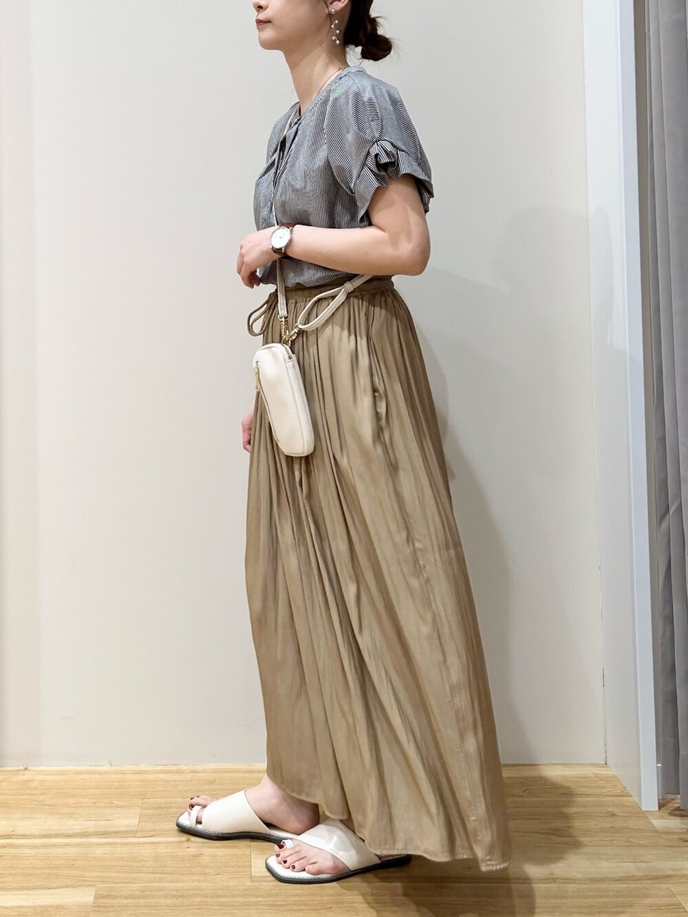 ホワイト系のサンダル、ベージュ系のその他パンツ、ホワイト系のショルダーバッグを着用したレディースの春コーディネートの2枚目の写真