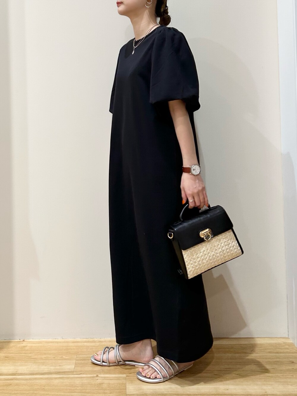 ブラック系のワンピース、シルバー系のサンダル、ブラック系のショルダーバッグを着用したレディースの夏コーディネートの2枚目の写真