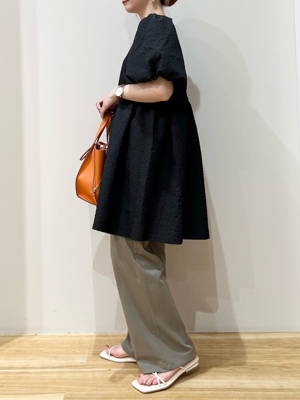 ブラック系のTシャツ/カットソー、オレンジ系のトートバッグ、ホワイト系のサンダルを着用したレディースの夏コーディネートの2枚目の写真