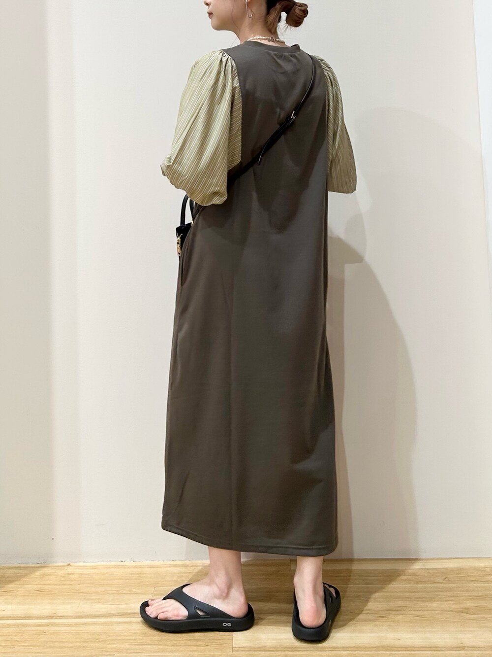 ブラック系のショルダーバッグ、ブラック系のサンダル、ブラウン系のワンピースを着用したレディースの夏コーディネートの3枚目の写真