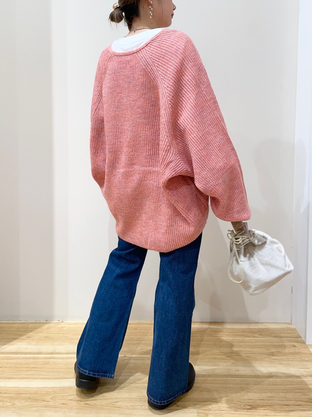 ホワイト系のTシャツ/カットソー、オレンジ系のニット/セーター、ベージュ系のショルダーバッグを着用したレディースの春コーディネートの4枚目の写真