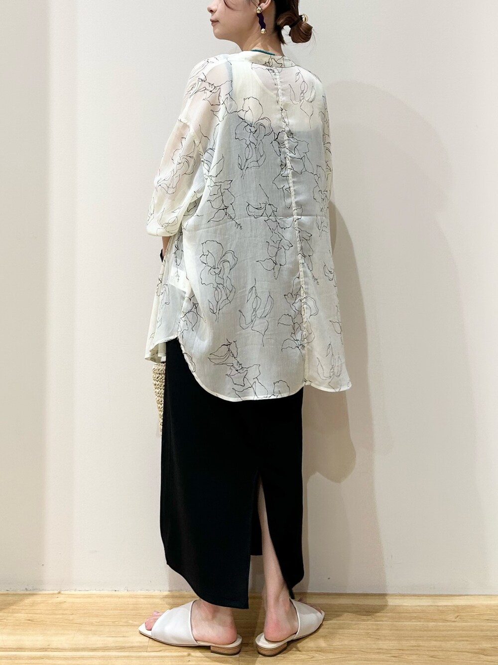 ベージュ系のかごバッグ、ホワイト系のサンダル、ブラック系のワンピースを着用したレディースの秋コーディネートの2枚目の写真