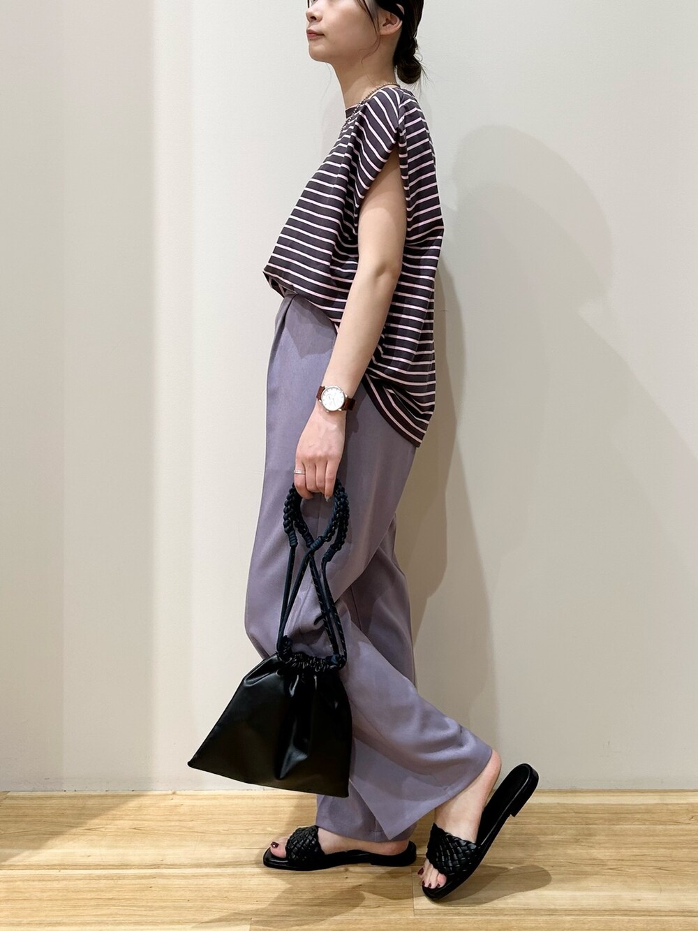 グレー系のTシャツ/カットソー、パープル系のスラックス、ブラック系のショルダーバッグを着用したレディースの夏コーディネートの2枚目の写真