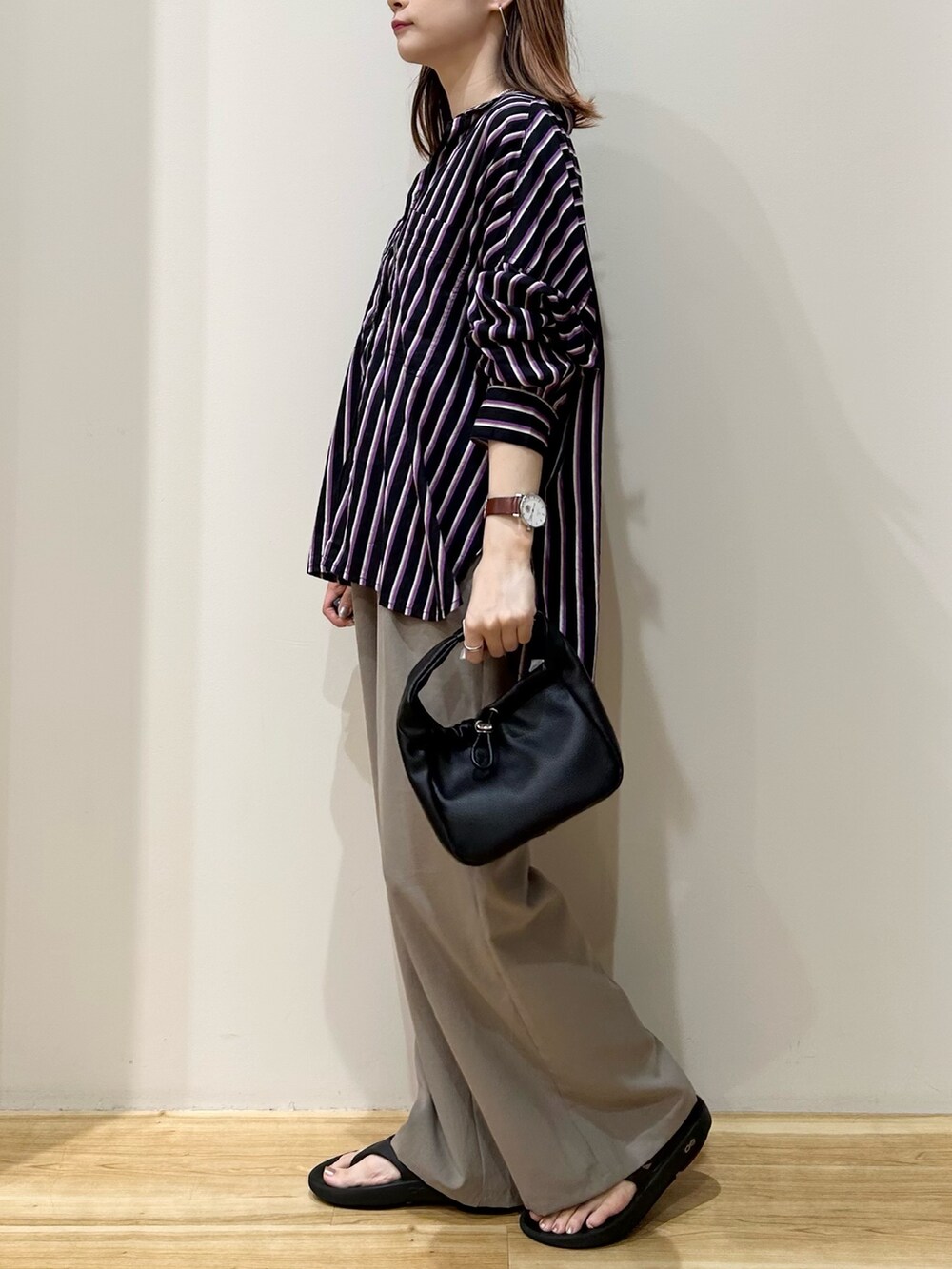 ブラック系のシャツ/ブラウス、ブラック系のハンドバッグ、ブラック系のサンダルを着用したレディースの夏コーディネートの2枚目の写真